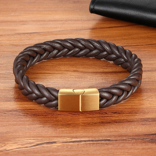 Brown braided leather bracelet with a gold clasp on a wooden surface