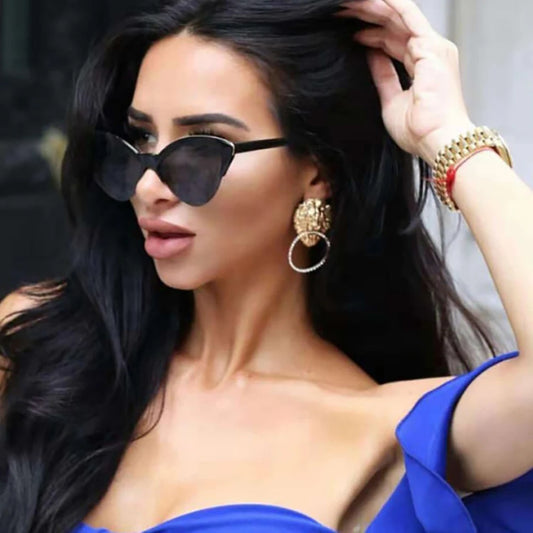 Woman wearing sunglasses and a blue top with a blurred background