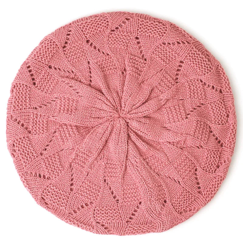 Pink knitted beret on a white background