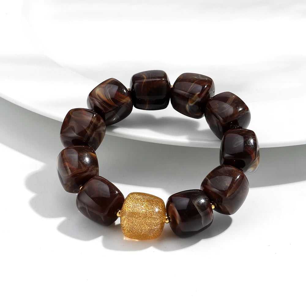 Brown beaded bracelet with a gold accent on a white background