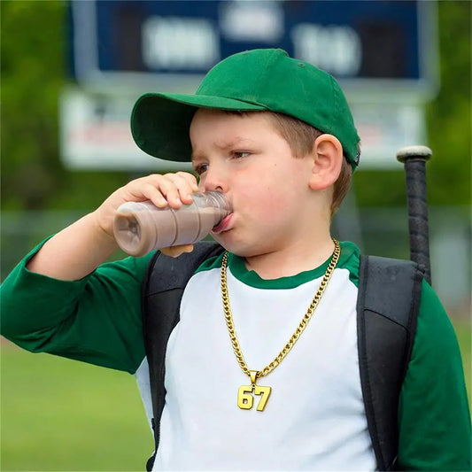 Child in green cap and backpack drinking from a bottle with a blurred background