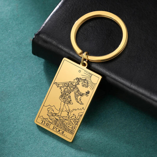 Gold tarot card keychain on a black book with a teal background