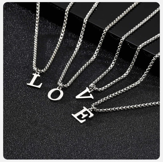 Silver necklaces with 'LOVE' pendants on a black background