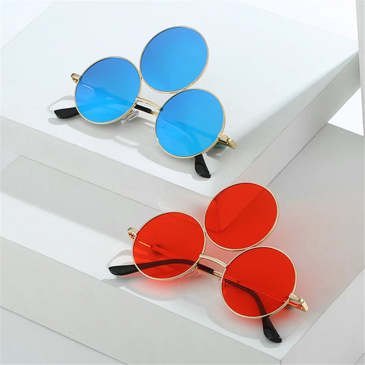 Two pairs of round sunglasses with blue and red lenses on a white surface.