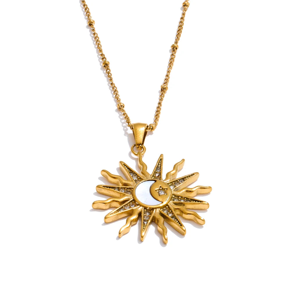 Gold sun and moon pendant necklace on a white background