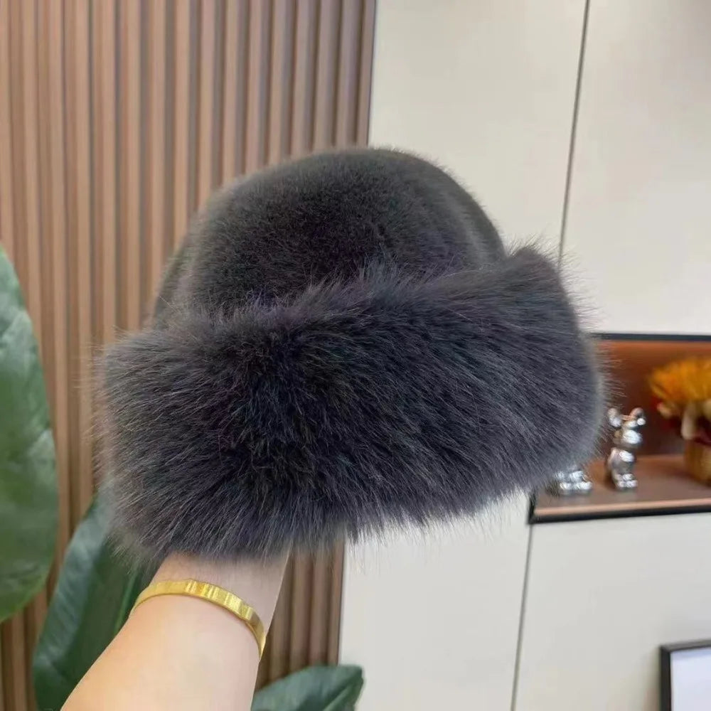 A dark grey faux fur hat with a round shape and a visor.