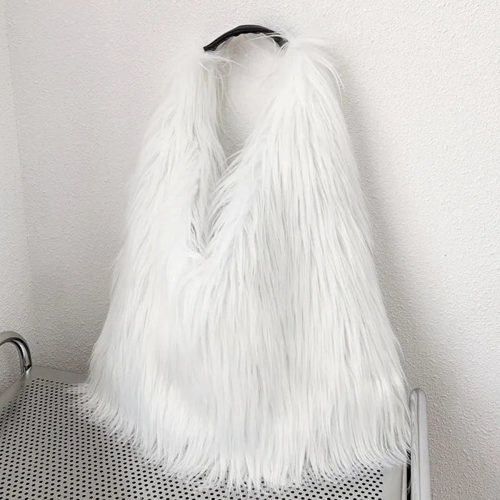 White fur handbag on a trolley against a white wall.