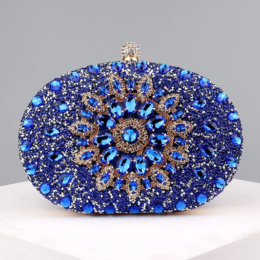 A blue and gold crystal embellished oval clutch bag with a hasp closure.