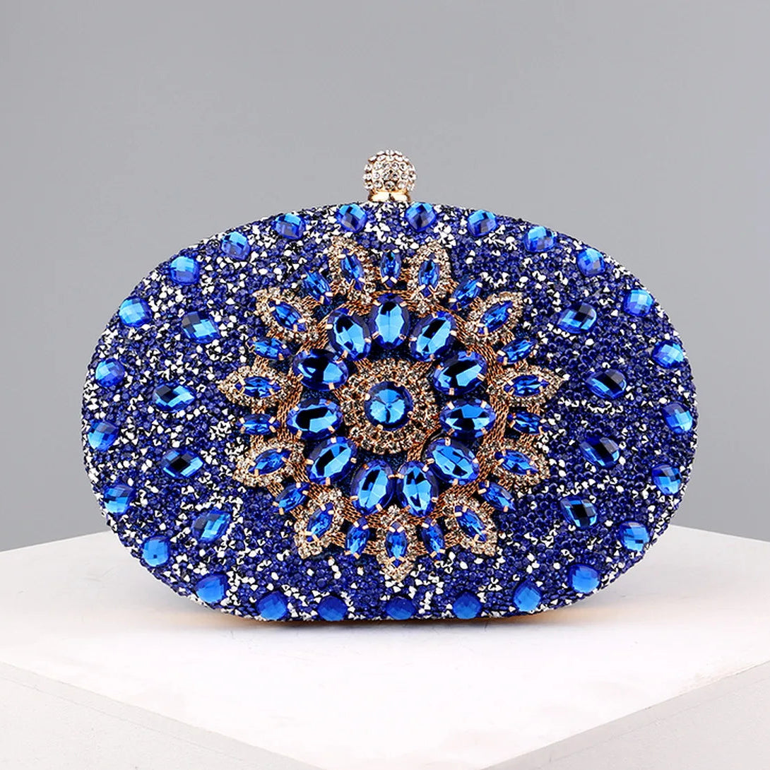 A blue and gold crystal embellished oval clutch bag with a hasp closure.