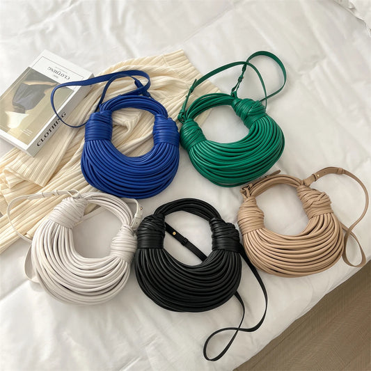 Five different colour handbags, blue, green, white, black and khaki with unique noodle design on white background.