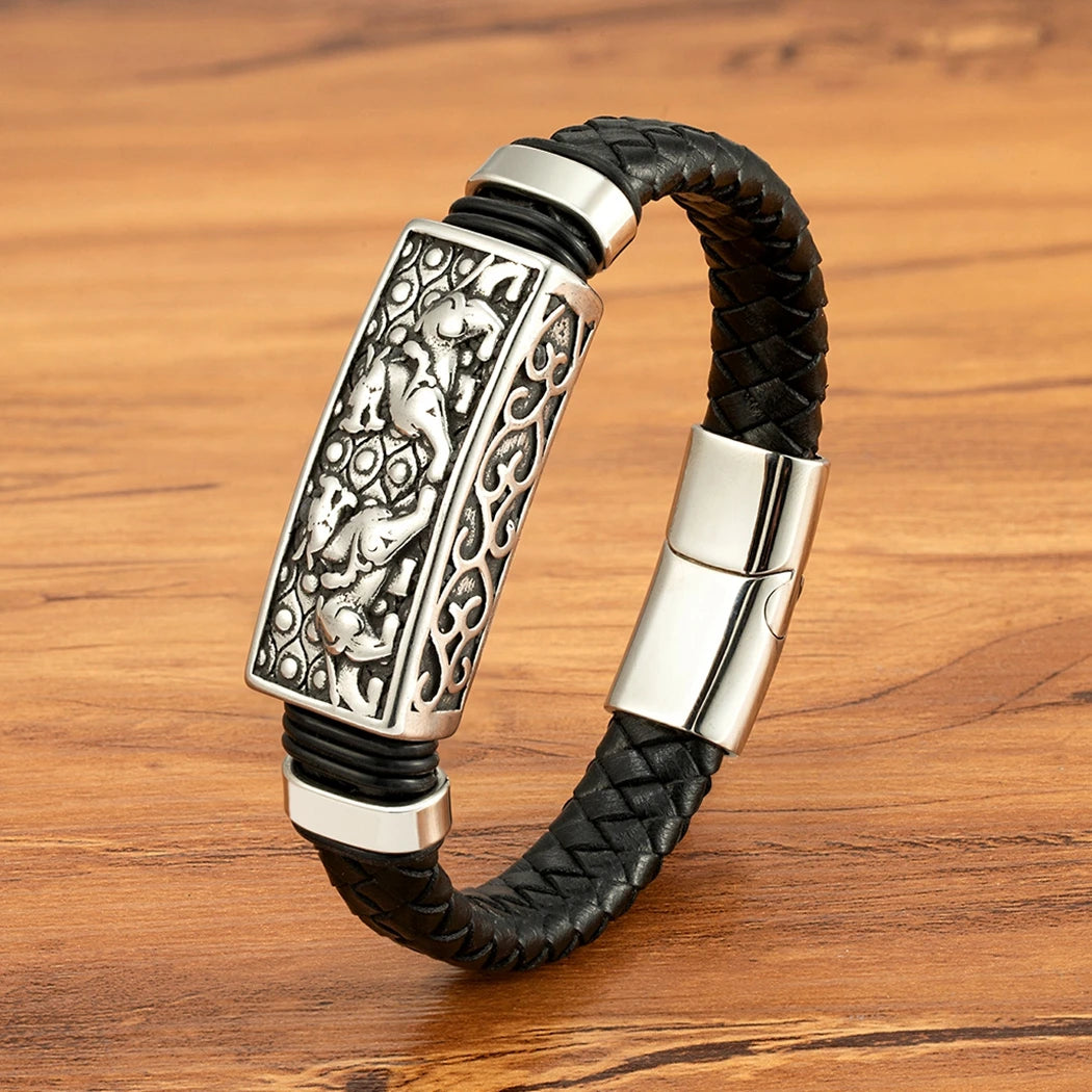 Black braided leather bracelet with silver clasp on a wooden surface