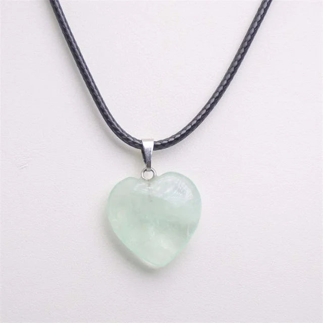 Heart-shaped jade pendant on a black cord against a white background