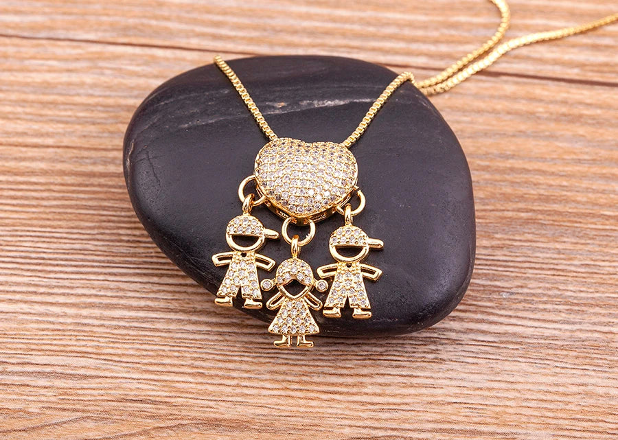 Gold necklace with heart pendant and child-shaped charms on a black stone