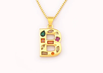 Gold necklace with a letter 'B' pendant featuring colourful gemstones on a white background