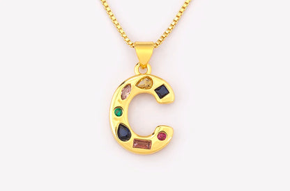 Gold necklace with a colourful 'C' pendant on a white background
