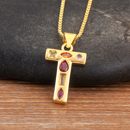Gold pendant with embedded gemstones on a wooden surface