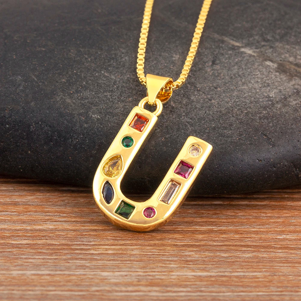 Gold pendant with colourful stones on a wooden surface