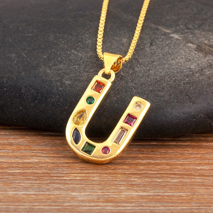 Gold pendant with colourful stones on a wooden surface