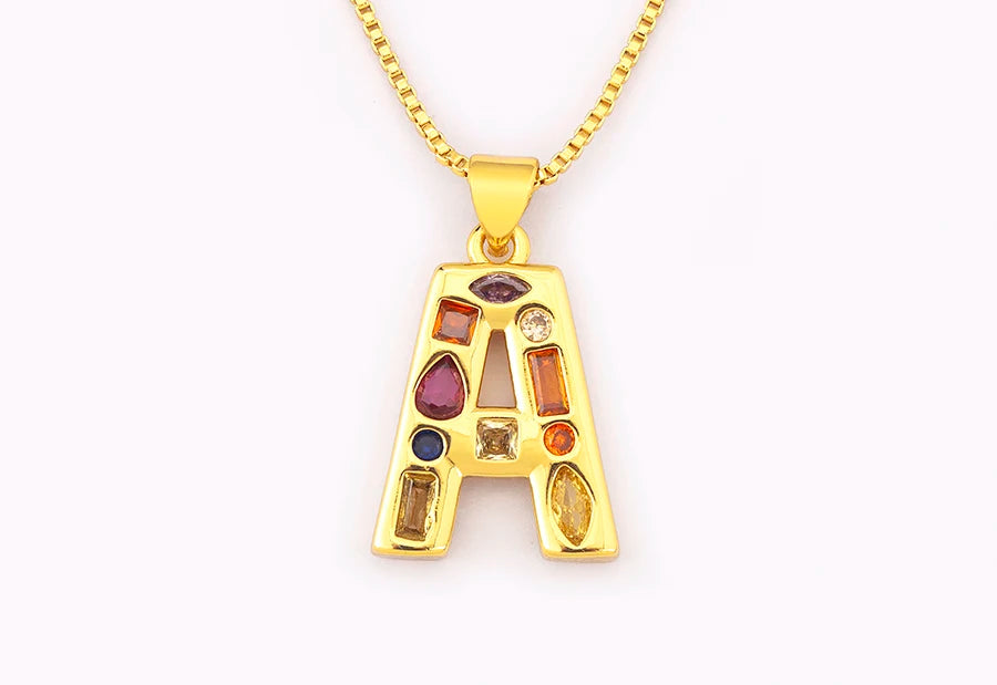 Gold necklace with a letter 'A' pendant featuring colourful gemstones on a white background