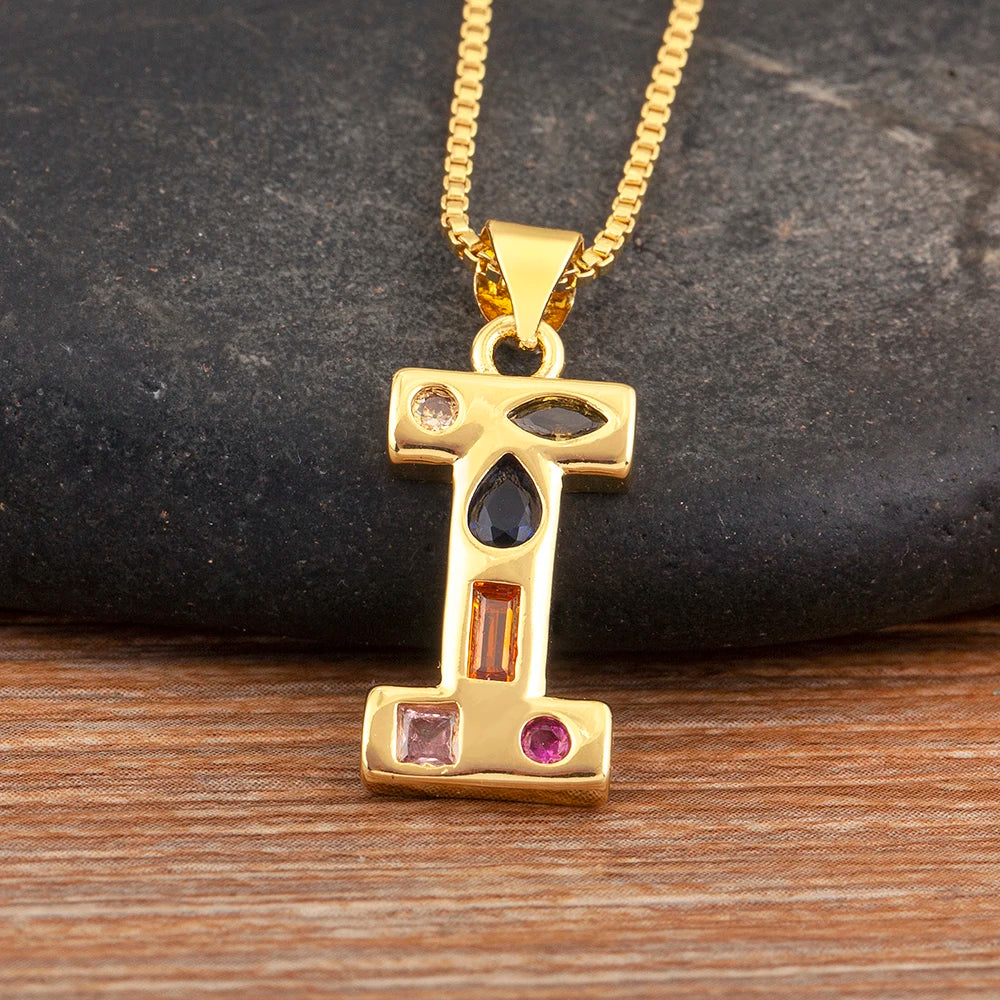 Gold pendant with gemstones on a chain against a stone background