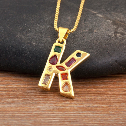 Gold pendant with colourful gemstones on a wooden surface