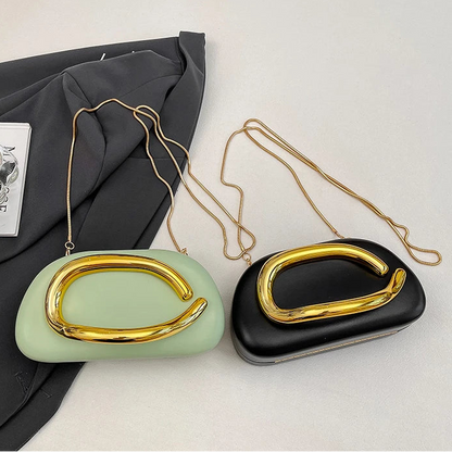 Two handbags, one green and one black, with gold accents on a light grey background.