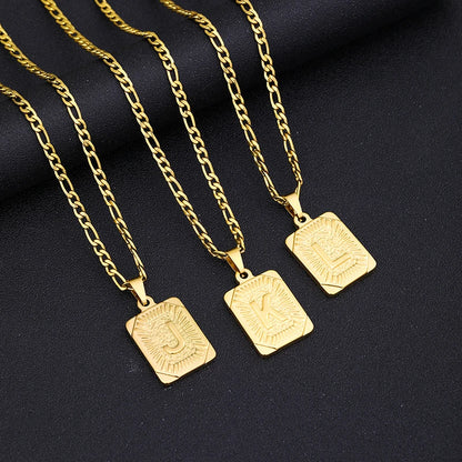 Three gold necklaces with square pendants on a black background