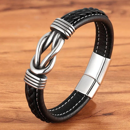 Black leather bracelet with silver metal clasp on a wooden surface