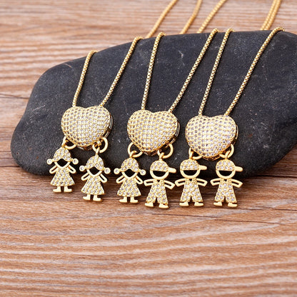 Gold heart-shaped pendant with child charms on a stone surface