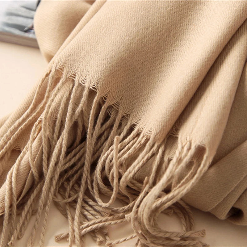 Beige scarf with tassels on a light background