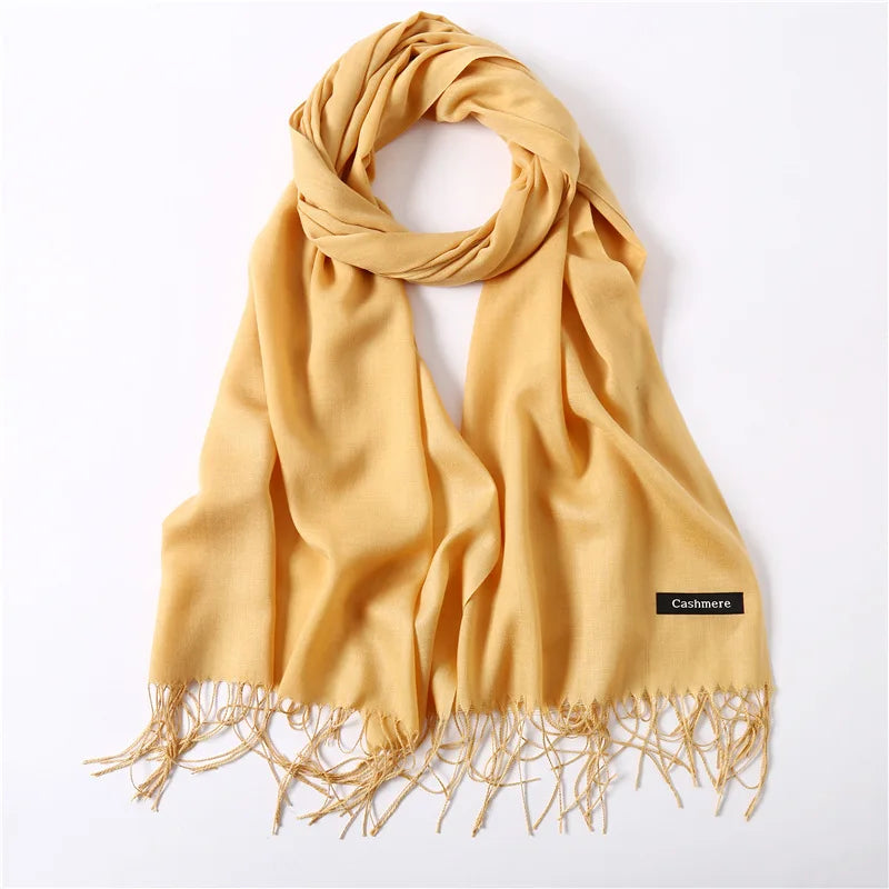 Yellow cashmere scarf with fringes on a white background