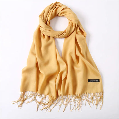 Yellow cashmere scarf with fringes on a white background
