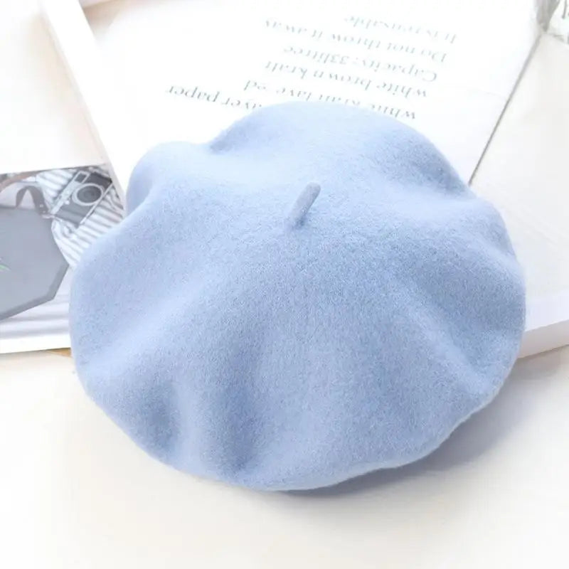 Light blue beret on a white surface with a magazine underneath