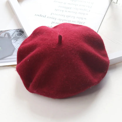 Red beret on a white surface with a magazine in the background