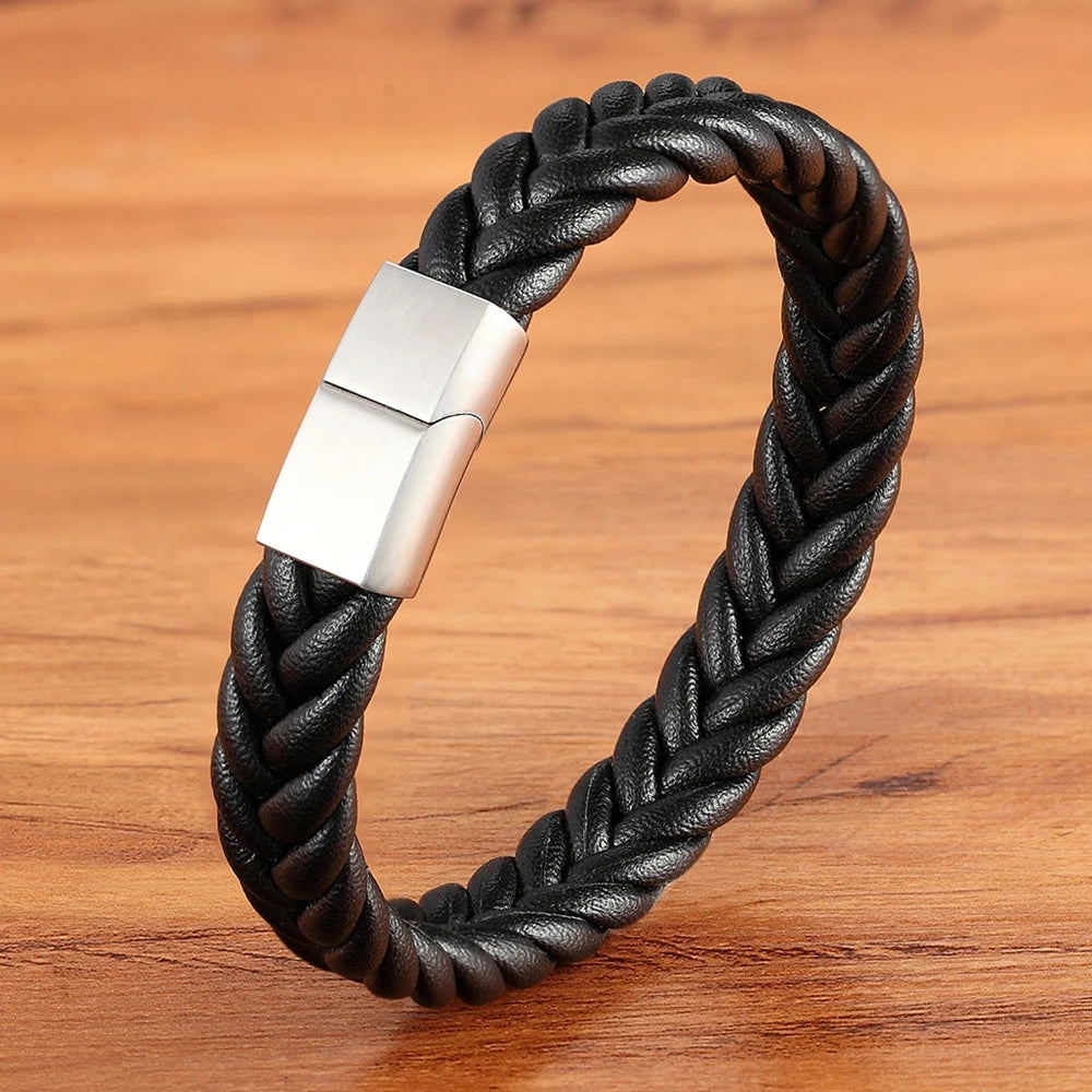 Black braided leather bracelet with a silver clasp on a wooden surface