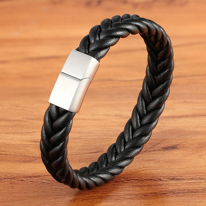 Black braided leather bracelet with a silver clasp on a wooden surface