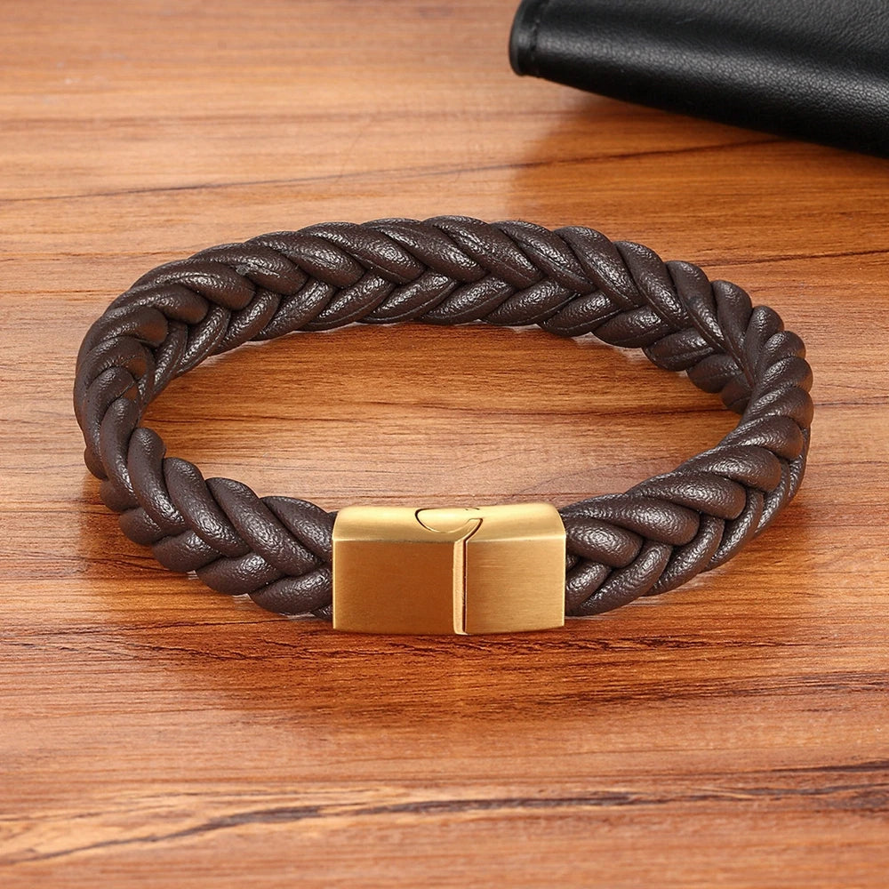 Brown braided leather bracelet with a gold clasp on a wooden surface