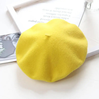 Yellow beret on a white surface with a magazine in the background