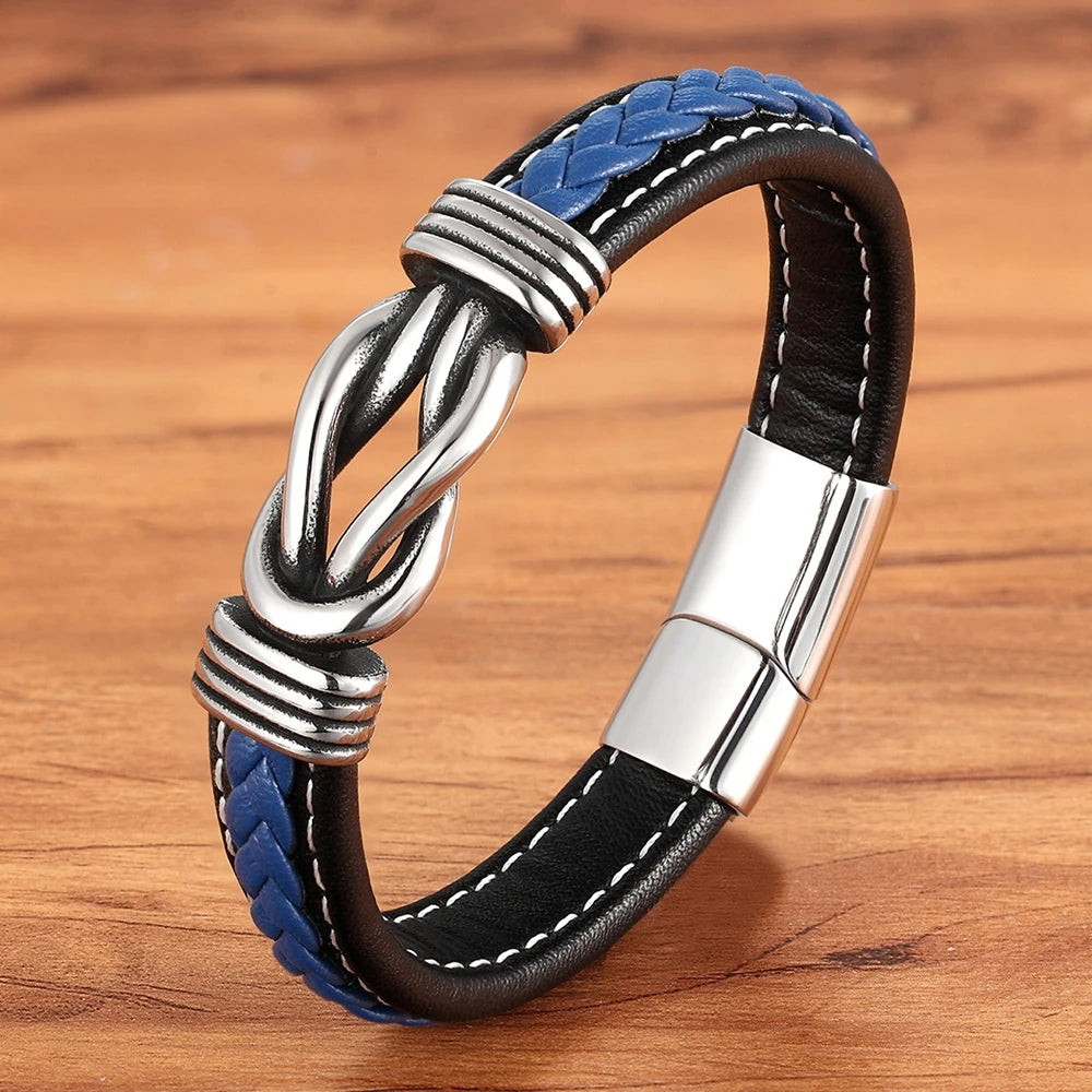 Black and blue braided leather bracelet with silver clasp on a wooden surface