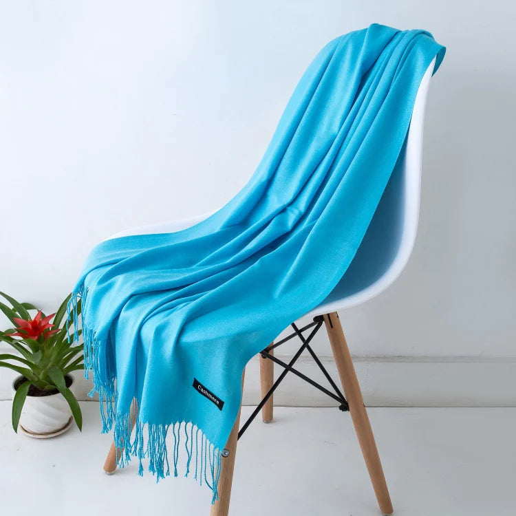 Turquoise scarf draped over a white chair with a plant in the background