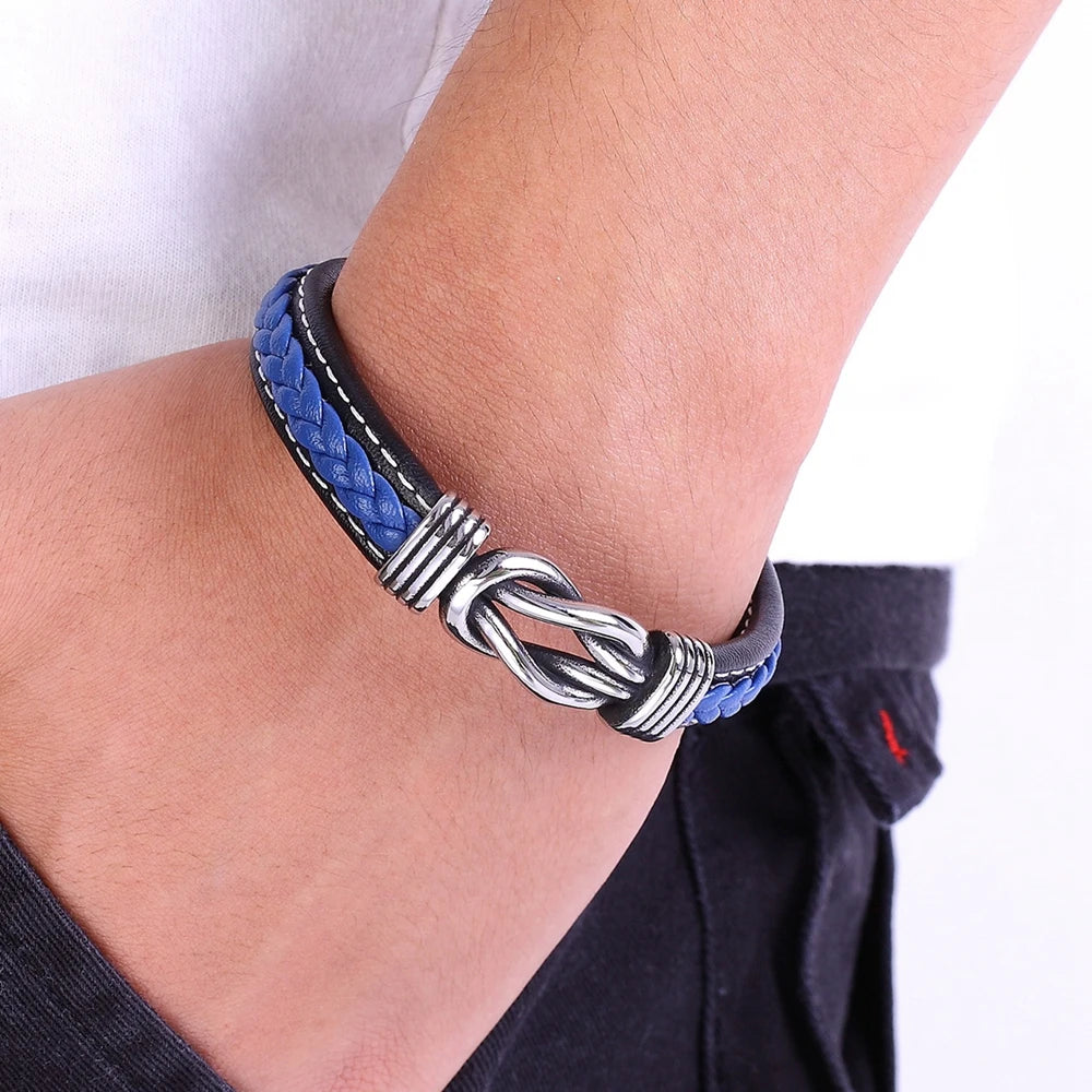 Bracelet with blue and black braided design on a wrist against a white background