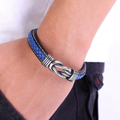 Bracelet with blue and black braided design on a wrist against a white background