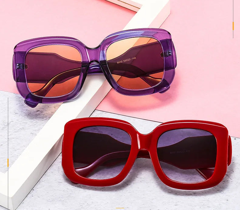 Two pairs of sunglasses, one purple and one red, on a light pink background with text overlay.