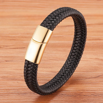 Black braided bracelet with a gold clasp on a wooden surface