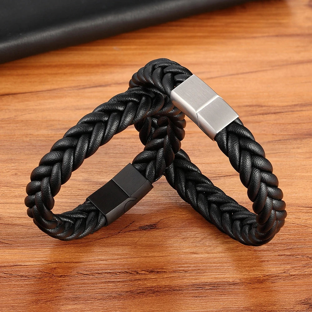 Black braided bracelet with silver and black clasp on a wooden surface