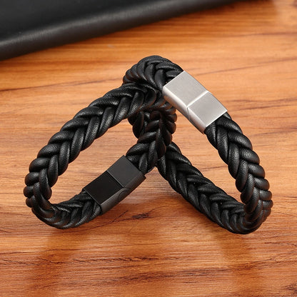 Black braided bracelet with silver and black clasp on a wooden surface