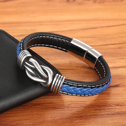 Black and blue braided leather bracelet with silver clasp on a wooden surface