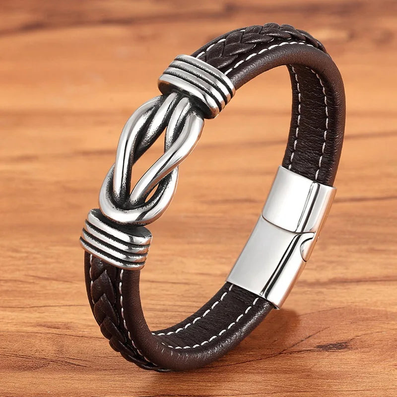 Brown leather bracelet with silver knot design on a wooden surface
