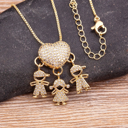 Gold necklace with heart pendant and child-shaped charms on a dark stone and wooden surface