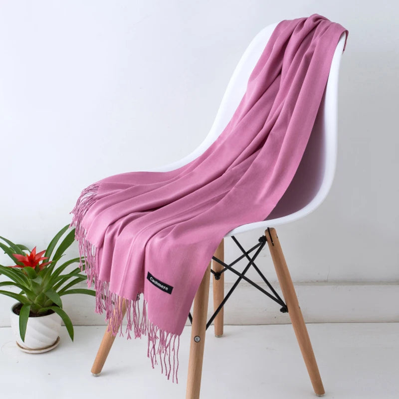Pink scarf draped over a white chair with a plant in the background